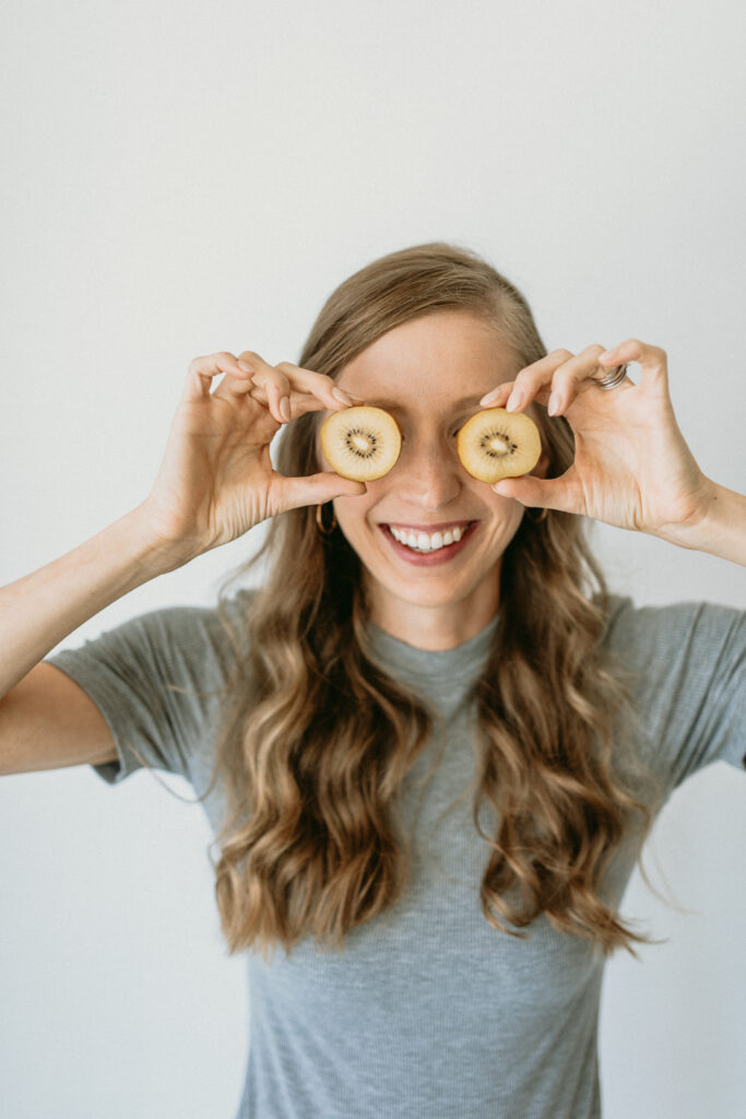 cindy, pediatric dietitian for babies and toddlers, holding kiwis to her eyes